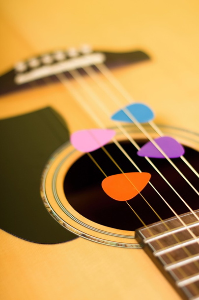 Four color guitar picks in strings - Photo, Image