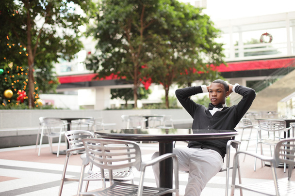 szép fekete férfi pihentető egy asztalnál - Fotó, kép