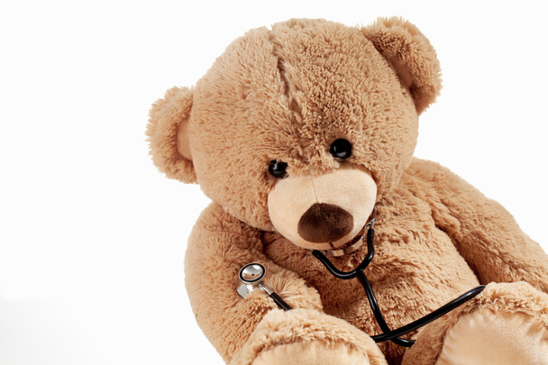 Teddybeer met stethoscoop op witte achtergrond - Foto, afbeelding