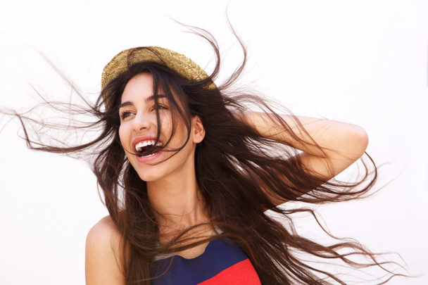 Mujer joven sonriente con el pelo largo soplando en el viento
 - Foto, Imagen