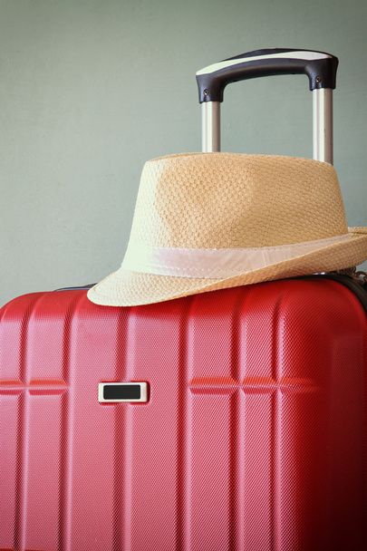 Red luggage and fedora hat - Zdjęcie, obraz