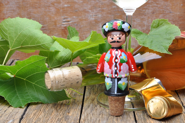 Cavatappi decorativi ungheresi, bottiglia di vino e bicchiere di vino sul tavolo di legno con ramoscelli verdi
 - Foto, immagini