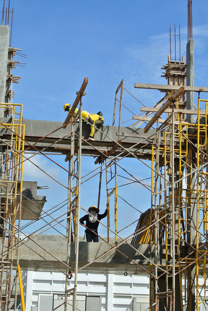 Gruppe von Bauarbeitern, die Balkenschalungen herstellen - Foto, Bild
