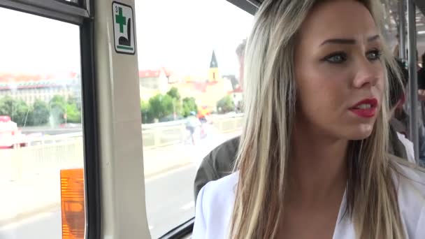 junge attraktive blonde Frau, die mit der Straßenbahn unterwegs ist und aus dem Fenster schaut - Nahaufnahme - Filmmaterial, Video