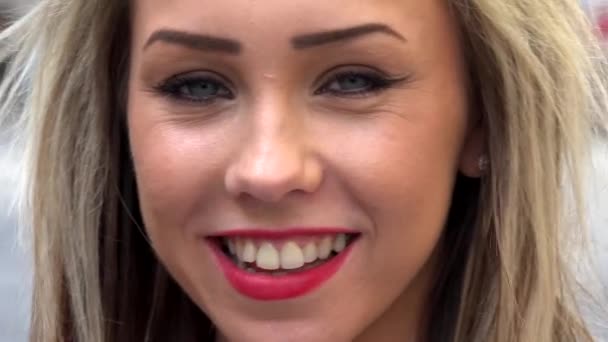 jovem mulher loira atraente sorri para a câmera - rua urbana na cidade - close-up
 - Filmagem, Vídeo