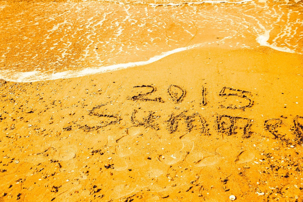 Напис пляжний пісок влітку 2015 року. Концепт фото літніх подорожей і відпусток
. - Фото, зображення