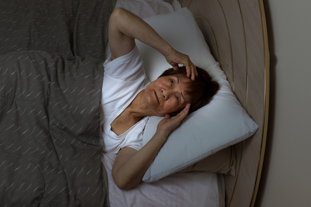 Neklidné starší žena zíral do stropu v noční době  - Fotografie, Obrázek