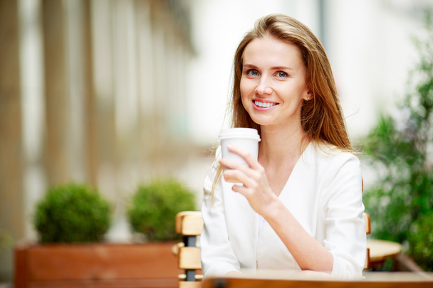 Mujer tomando café en la cafetería de la calle
 - Foto, imagen