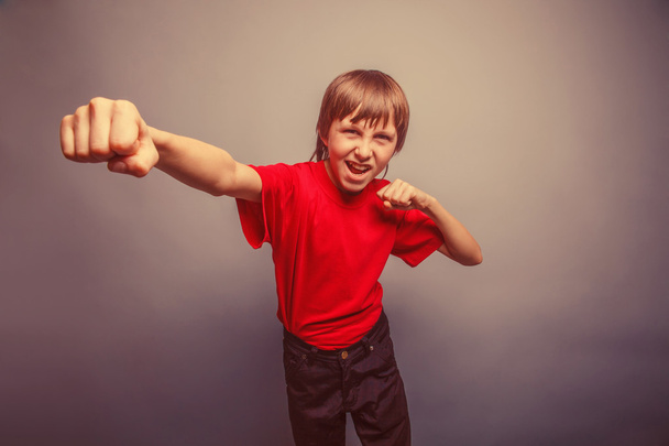 European-looking boy of ten years shows a fist, anger, danger, m - Photo, Image
