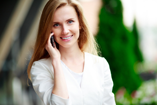 Young beautiful smiling woman talking on cell phone - Foto, Imagen