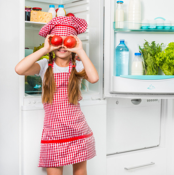 Little cook girl holdin tomatoes - 写真・画像