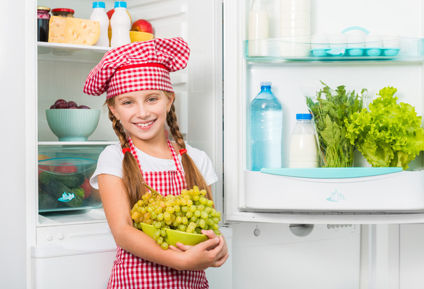 little cook girl holding grapes - Zdjęcie, obraz