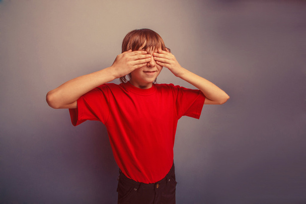 chico, adolescente, doce años en camiseta roja, ojos cerrados de manos
  - Foto, Imagen