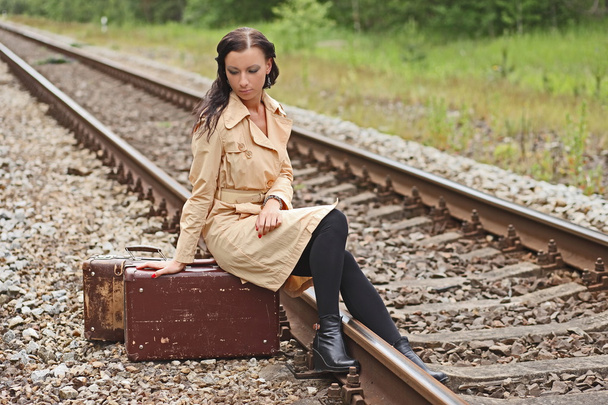 woman with a suitcase on the rails - Фото, изображение