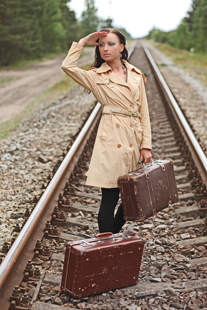 vrouw met een koffer op de rails - Foto, afbeelding
