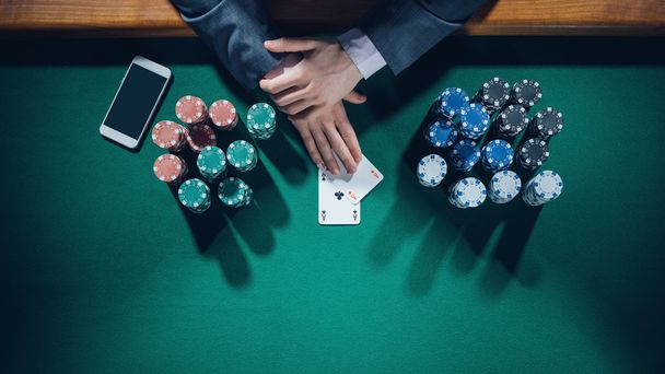 poker player with smartphone holding two aces - Foto, Imagem