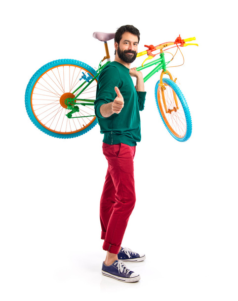 Hipster με τον αντίχειρα επάνω κρατώντας ένα ποδήλατο - Φωτογραφία, εικόνα