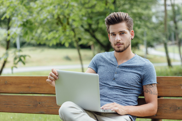 Handsome man using a laptop - Фото, изображение