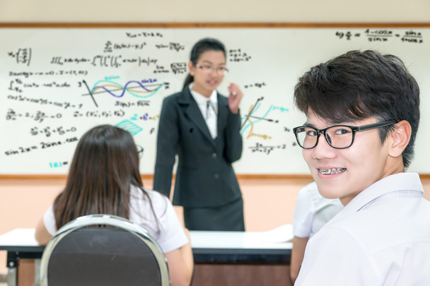 Groep van Aziatische leraar en leerlingen in uniform op klas - Foto, afbeelding