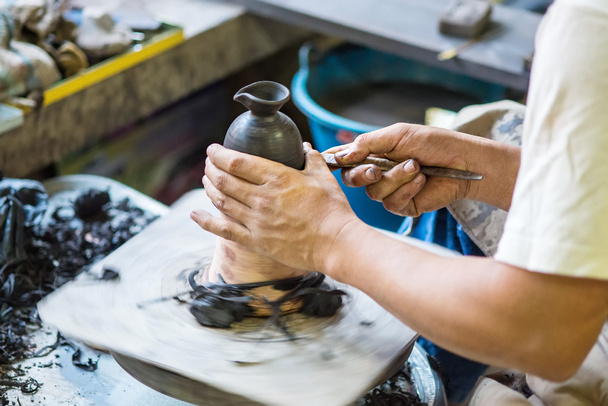 Hands working on pottery wheel - Foto, afbeelding