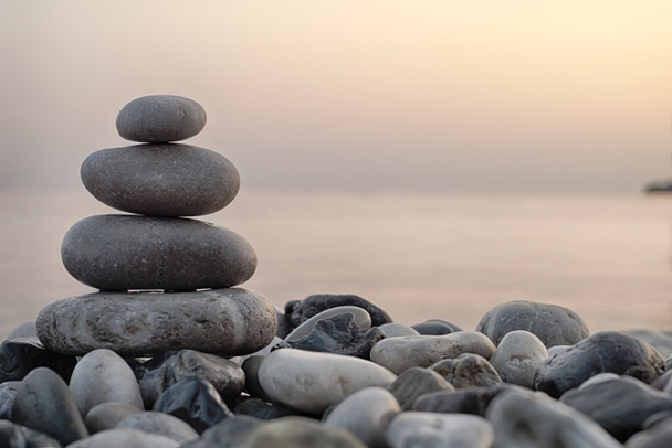 Стопка круглых гладких камней на берегу моря
 - Фото, изображение