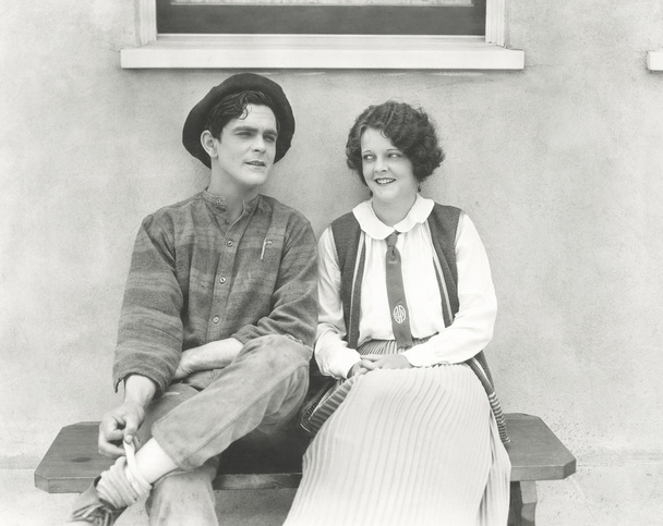 Fiatal férfi és a nő ül a szabadban - Fotó, kép