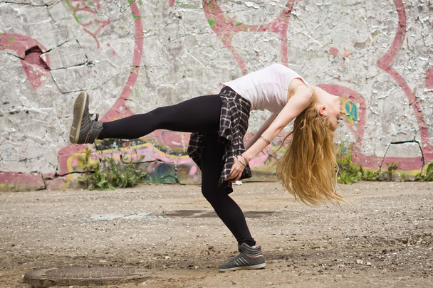 Young girl dancing on graffiti background - Фото, изображение