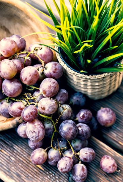 uvas moradas con hojas en el plato de madera
 - Foto, Imagen