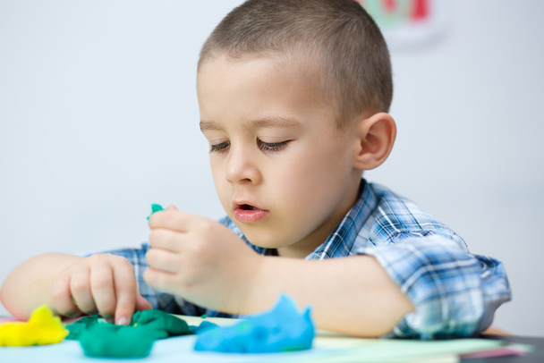Boy playing with color play dough - Fotó, kép