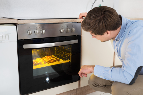Man Baking Bread In Oven - Foto, immagini
