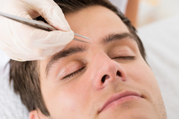 Beautician Hands Plucking Man Eyebrows With Tweezers - Foto, Bild