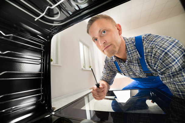 Repairman Fixing Kitchen Oven - Foto, Bild