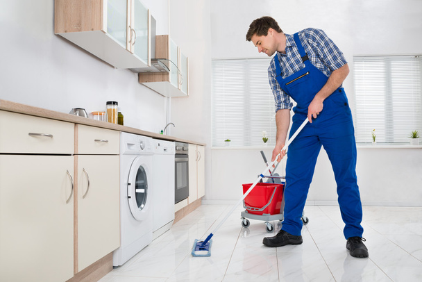 Worker Mopping Floor In Kitchen - Valokuva, kuva