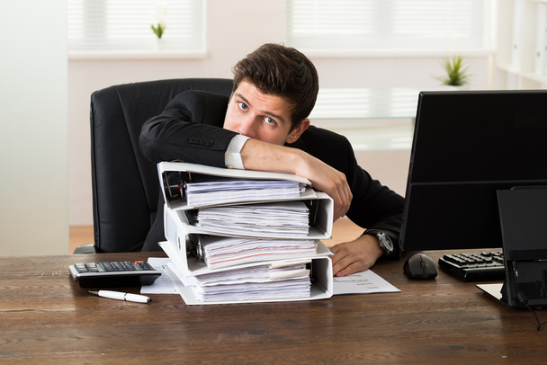 Businessman Leaning On Stack Of Folders - Foto, Bild