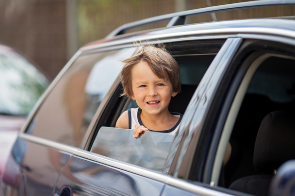 Little cute child, boy, looking out the window of a car - Фото, изображение