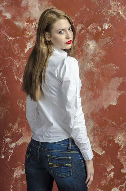 Young slim beautiful young blond woman with long legs and hair in shirt and jeans - Foto, Bild