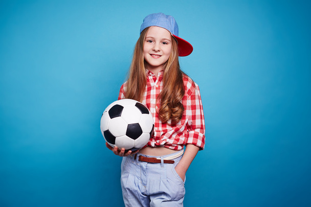 Улыбающаяся девушка держит футбольный мяч
 - Фото, изображение