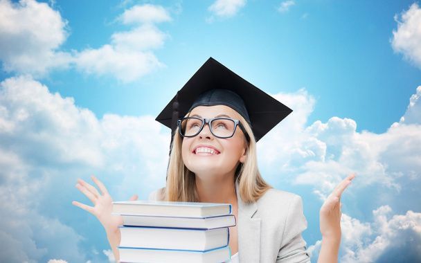happy student girl in bachelor cap with books - Photo, image
