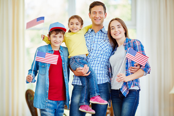 Familia americana sosteniendo banderas
 - Foto, Imagen