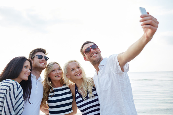 happy friends on beach and taking selfie - Photo, Image