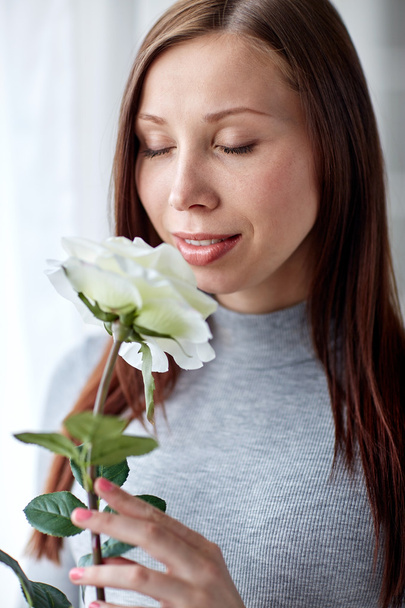 happy woman smelling big white rose at home - Fotoğraf, Görsel