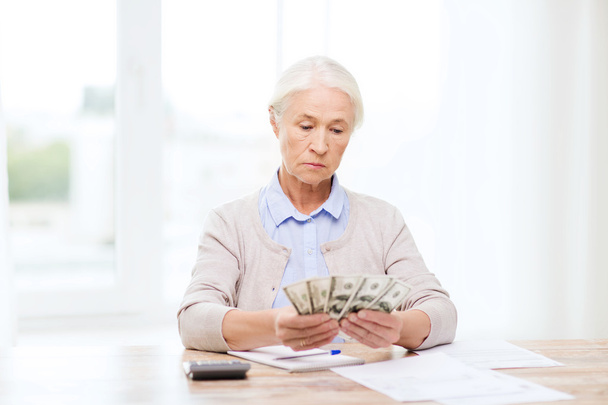senior woman with money and papers at home - Foto, immagini