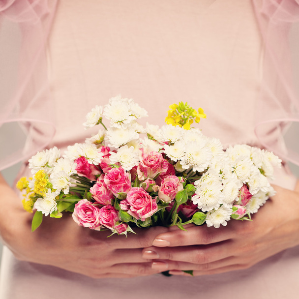 Regalo de flores en manos de mujer. Fondo floral rosa
 - Foto, Imagen