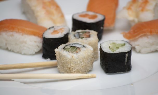 Diferentes rollos de sushi japanase con chopstic
  - Foto, imagen