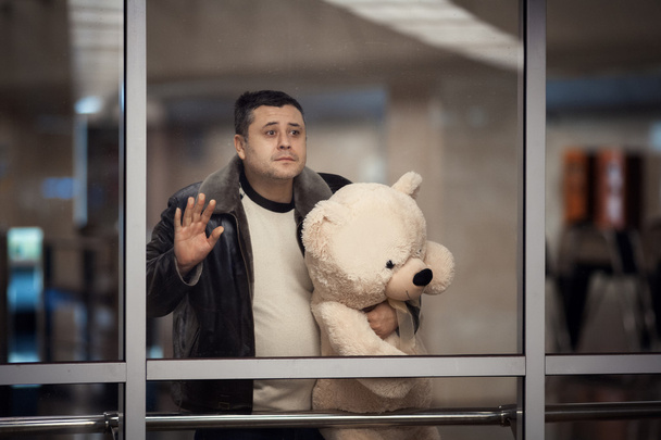 Man holding toy bear and looking sadly into the distance. - Fotó, kép
