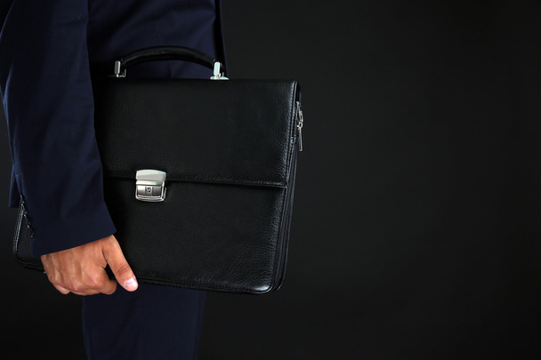 Elegant man in suit with briefcase on dark background - Fotografie, Obrázek