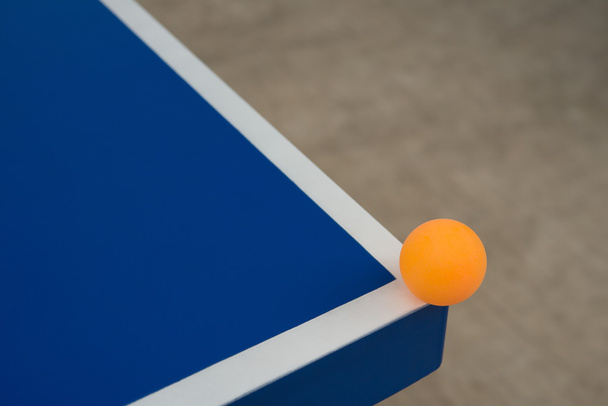 bola pingpong atinge o canto de uma mesa azul pingpong
 - Foto, Imagem