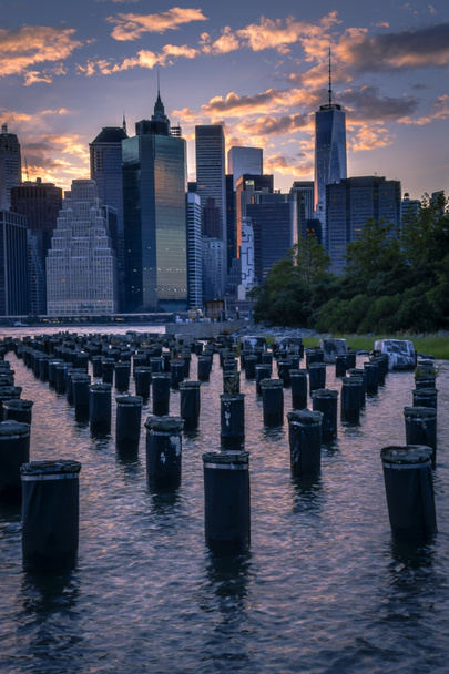 New York skyline seen from Brooklyn across the east river with some wooden pylons - Photo, Image