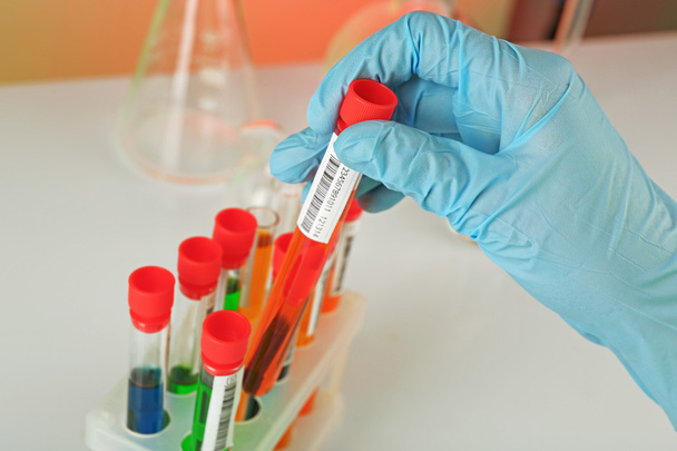 Test tubes with colorful liquid in scientist hand, closeup - Valokuva, kuva