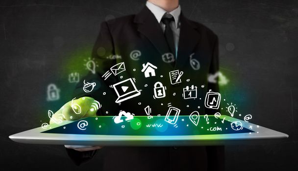 Persona sosteniendo la tableta con iconos y símbolos de medios verdes - Foto, imagen